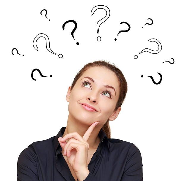 Woman looking up at question marks