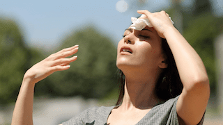 Woman shielding her face from bright sunlight